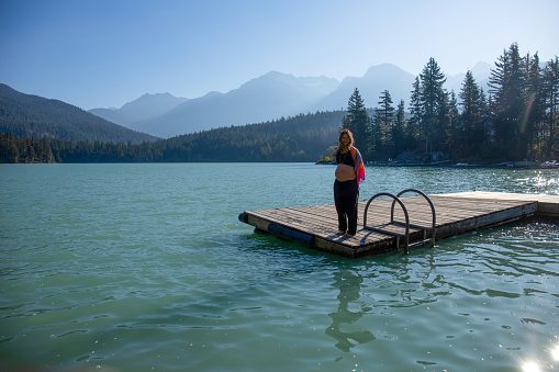 With her pregnant belly exposed, she soaks up the sunshine. At Green Lake, in Whistler, BC.