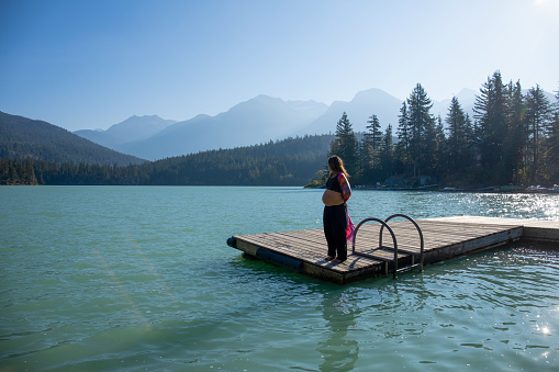 With her pregnant belly exposed, she soaks up the sunshine. At Green Lake, in Whistler, BC.