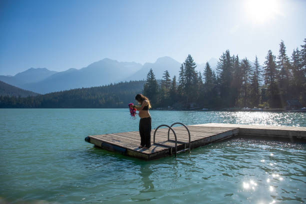 With her pregnant belly exposed, she soaks up the sunshine. At Green Lake, in Whistler, BC.