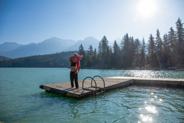 istock Young woman relaxes on lakeside dock in the morning 1719084749