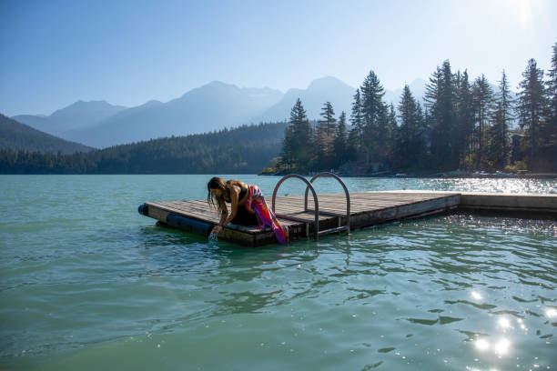 istock Young woman relaxes on lakeside dock in the morning 1719084761