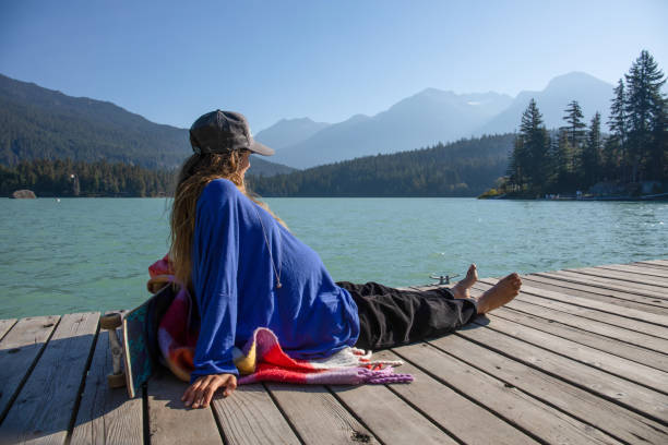 istock Young woman relaxes on lakeside dock in the morning 1719085392