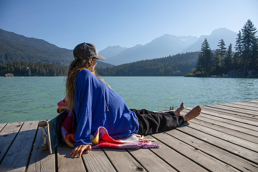 With her pregnant belly exposed, she soaks up the sunshine. At Green Lake, in Whistler, BC.