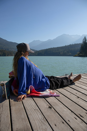 With her pregnant belly exposed, she soaks up the sunshine. At Green Lake, in Whistler, BC.