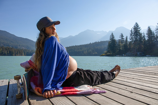 With her pregnant belly exposed, she soaks up the sunshine. At Green Lake, in Whistler, BC.