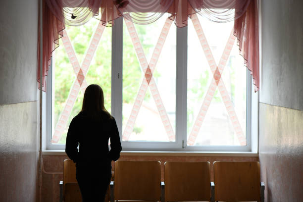 the girl stands at the school windows glued crosswise. war in ukraine. high resolution photo. - distress rocket imagens e fotografias de stock