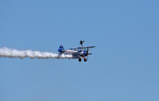 Ickwell, Bedfordshire, England - August 07, 2022: Aerosuperbatics wing walking display team aeroplane in flight. Wing walker.