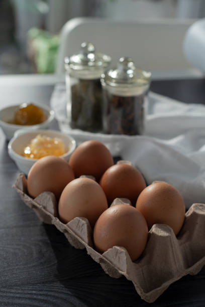 Eggs in the paper egg carton. Fig jam and natural honey.Colorful chicken eggs in cartons tray.