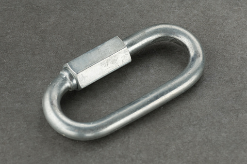 Metal carabiner on a gray background