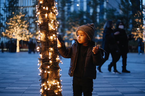 Kid playing around Christmas decorations in New York