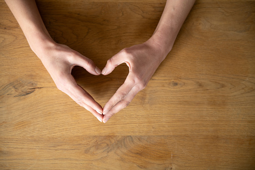 Hands Heart Shape on wooden table