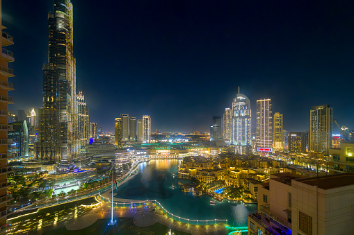 Night view of downtown Dubai illuminated including the Dubai Fountain, Dubai mall and Burj Khalifa in Dubai, United Arab Emirates. Downtown Dubai is the city’s busy tourism hub, home to the towering Burj Khalifa skyscraper, with its observation deck, and the dancing Dubai Fountain, where crowds ga