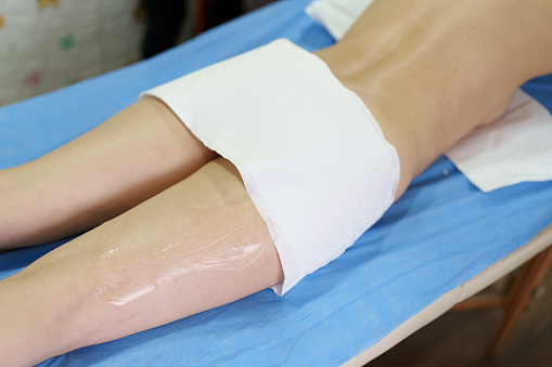 applying gel on woman's legs for massage