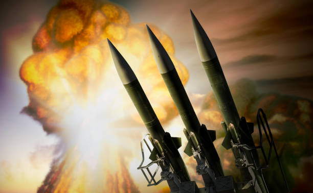 istock Warhead missiles and nuclear explosion mushroom cloud in background. War concept. 3D rendered illustration. 1719169307