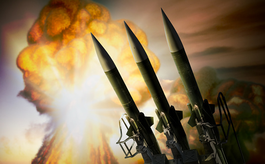 Warhead missiles and nuclear explosion mushroom cloud in background. War concept. 3D rendered illustration.