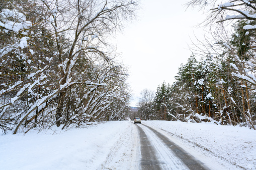 Ulyanovsk, Russia - February 13, 2022: Snowy winter road in a mountain forest. Beautiful winter landscape.
