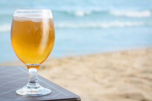 istock Cold beer in glass on beach. Space for text 1719193036