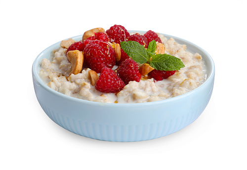 Bowl with tasty oatmeal porridge on white background. Healthy meal