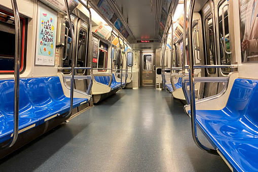 An empty subway car in New York City, Manhattan, with the iconic NYC skyline in the background.
