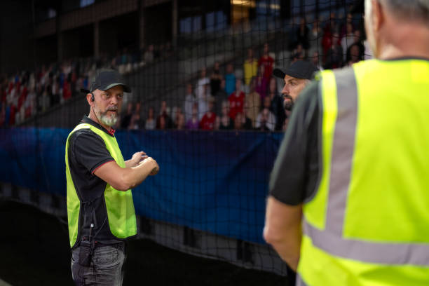 istock Soccer field male workers in reflective vests 1719200587