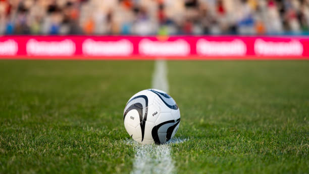 istock Football ball on white marking line on field 1719200593