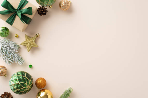 istock Get Festive: Top-view perspective showcasing craft paper giftbox, glittering tree ornaments, green, orange, and gold baubles, star decor, frosty fir twig on soft beige canvas, space for your message 1719212997