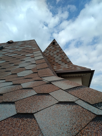A fragment of a roof made of bitumen tiles. Construction of houses.