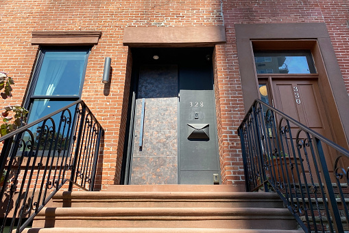 A classic brownstone entrance with an ornate facade, featuring a staircase leading to the front door, exuding timeless charm and elegance.