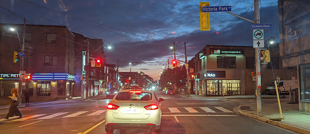 Toronto, Canada - August 26, 2023: Looking west on Kingston Road at Victoria Park Avenue. Twilight with dramatic clouds over The Beaches neighborhood on a Saturday night.