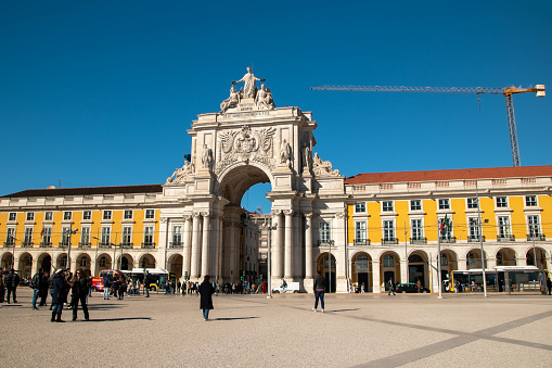 Lisbon, Portugal's iconic Praca do Comercio, where historical buildings frame a bustling European square, offering a picturesque and cozy cityscape as people traverse the charming Portuguese streets.