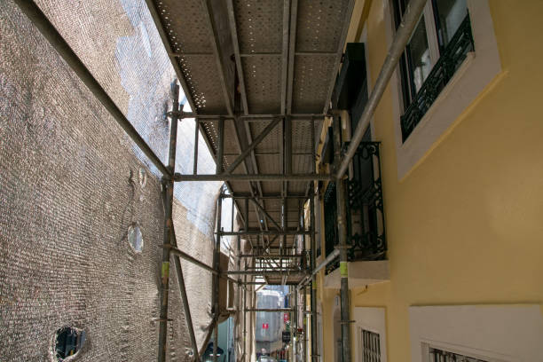 lissabon, portugal, rekonstruktion der fassade eines historischen mehrfamilienhauses an einer stadtstraße, fassadenbaugewebe deckt ein altes haus ab, das für die renovierung geschlossen wurde wand außen - restoring house scaffolding history stock-fotos und bilder