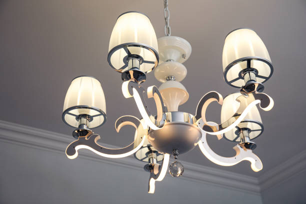 istock Stylish chandelier on ceiling in light room 1719285561