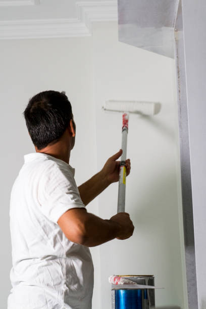Rear View Of Wall Painter At Home