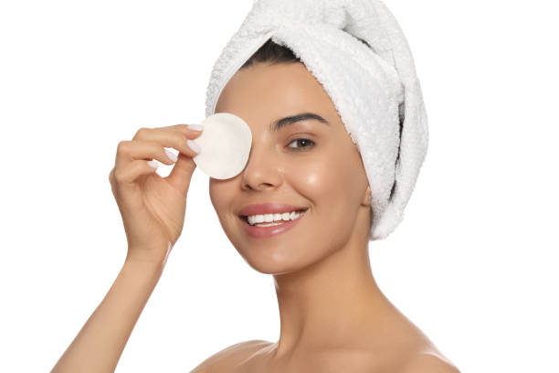 istock Young woman using cotton pad with micellar water on white background 1719332912