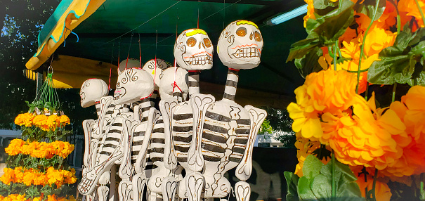 In Playa del Carmen, Mexico skeletons used to decorate and celebrate the Day of the Dead are hanging for sale at an outdoor market.