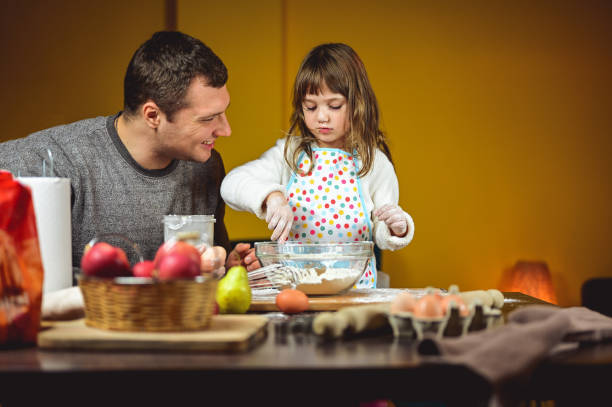 istock father with daughter cooking together in a kitchen. 1719355682
