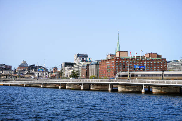 istock View of buildings by river against clear blue sky 1719363356