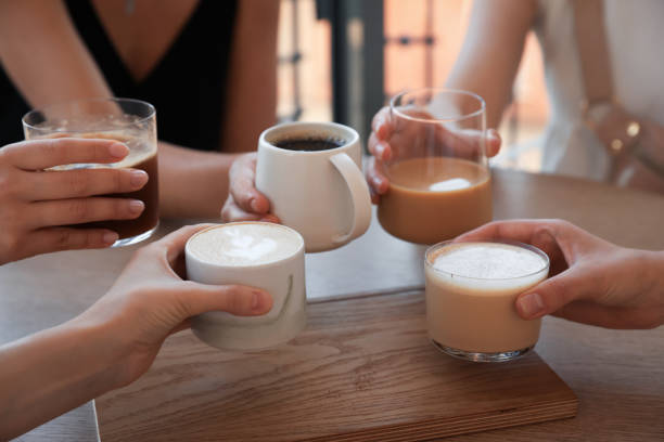 istock Friends drinking coffee at wooden table in cafe, closeup 1719364861
