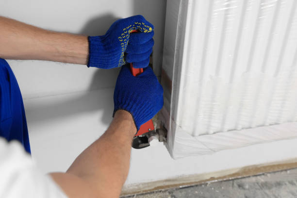 istock Professional plumber using adjustable wrench for installing new heating radiator indoors, closeup 1719366434
