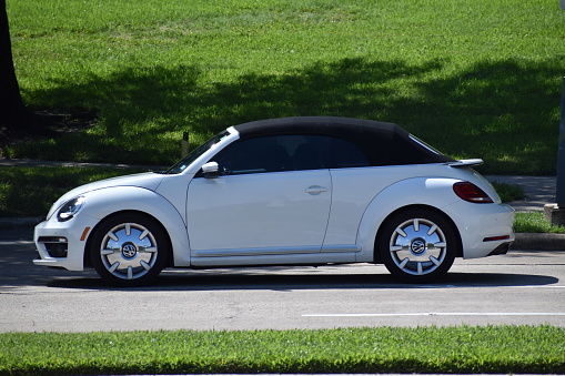 Houston, TX USA 10-1-2023 - A portrait of a white Volkswagen Beetle cruising near Herman Park in Houston