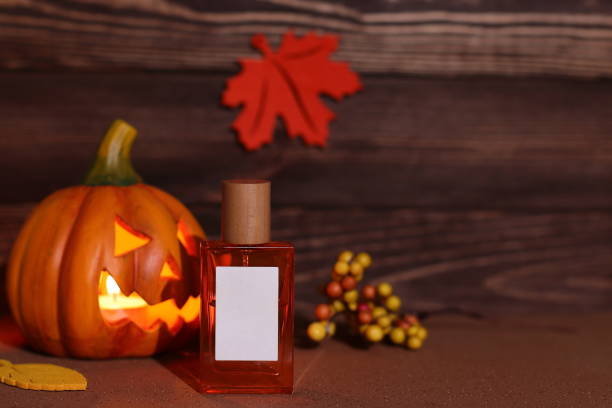 プムキンの顔をしたガラスの香水瓶、ハロウィーンの香り - glass autumn halloween food ストックフォトと画像