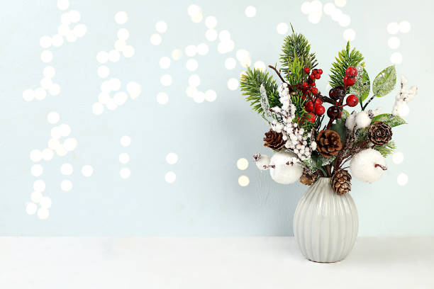 istock Empty table with a live Christmas tree in a vase, with pine cones and homemade decorations on a bokeh background. Christmas and New Year eco layout for design 1719387082