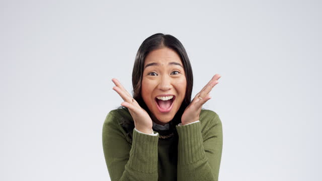 Winner, surprise and face of Asian woman on a white background with success, wow and victory. Studio, surprise and portrait of isolated excited person for winning competition, bonus and giveaway