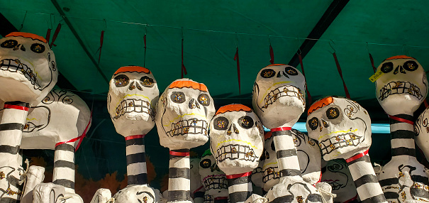 In Playa del Carmen, Mexico skeletons used to decorate and celebrate the Day of the Dead are hanging for sale at an outdoor market.