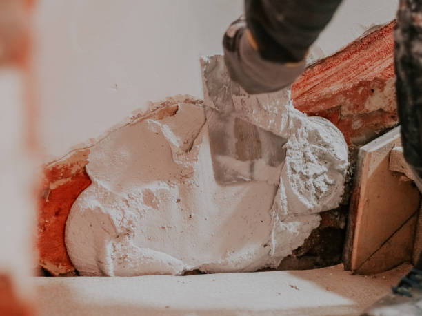 istock A man is putting putty on a hole in the wall. 1719432764