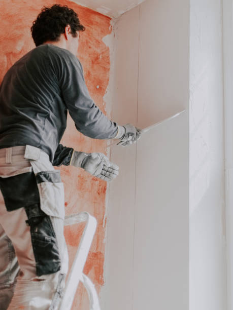 istock A Caucasian young man is putting putty on the wall. 1719433303