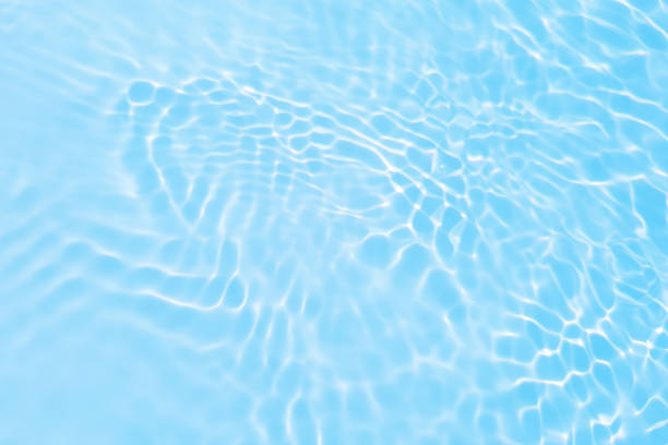 istock Defocus blurred transparent blue colored clear calm water surface texture with splashes reflection. Trendy abstract nature background. Water waves in sunlight with copy space. Blue watercolor shine. 1719444482