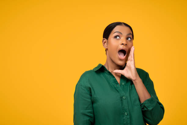 istock African Lady Shouting Advertising Offer At Empty Space, Yellow Background 1719466235
