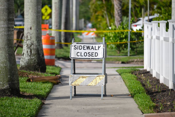 istock Warning sign that sidewalk is closed at street construction site. Utility work ahead 1719470614