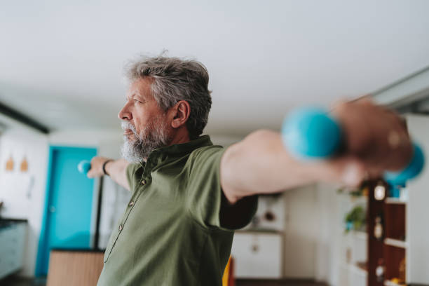 istock Elderly man exercising at home with dumbbell physiotherapy 1719536388